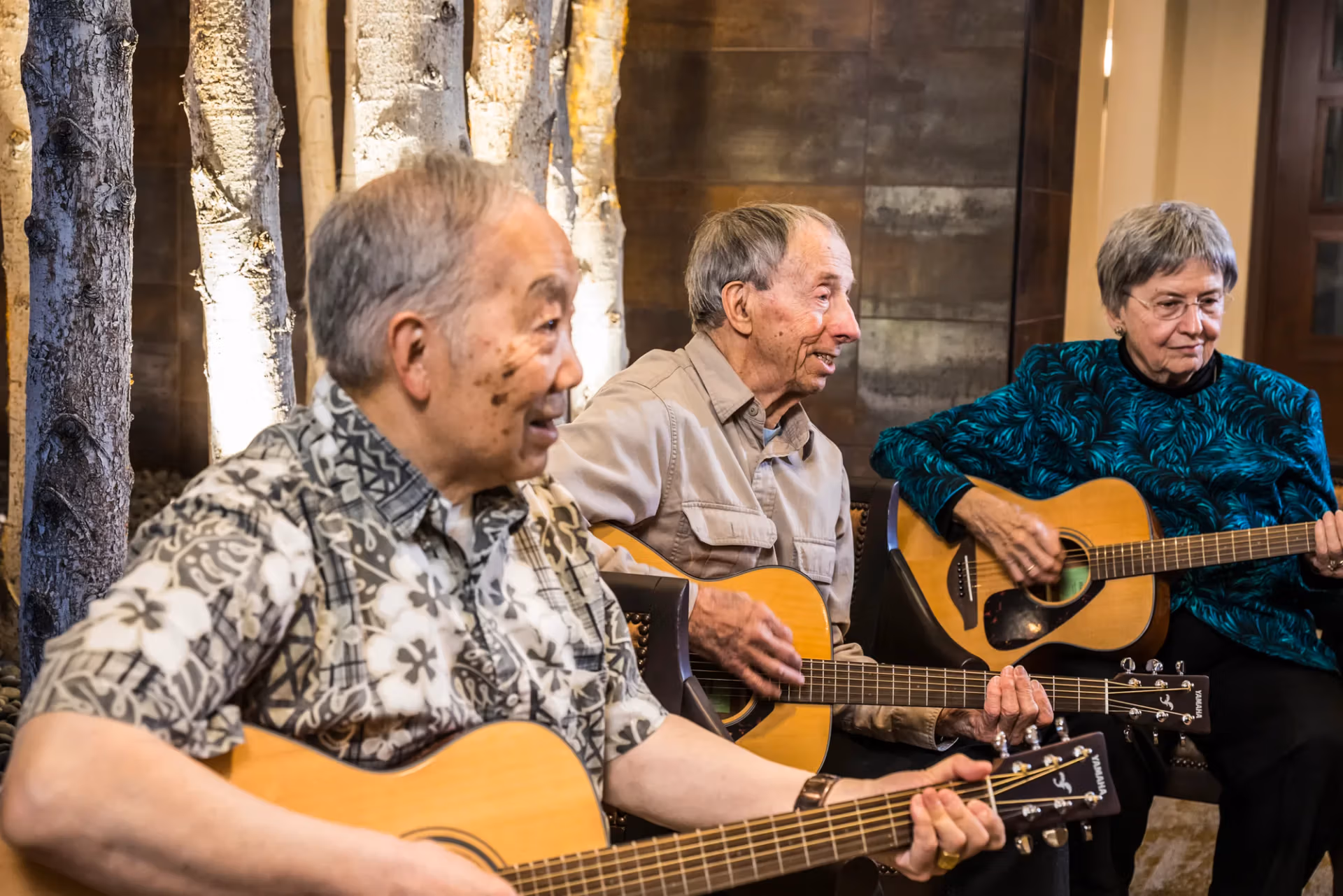 Residents playing guitars together in a music session