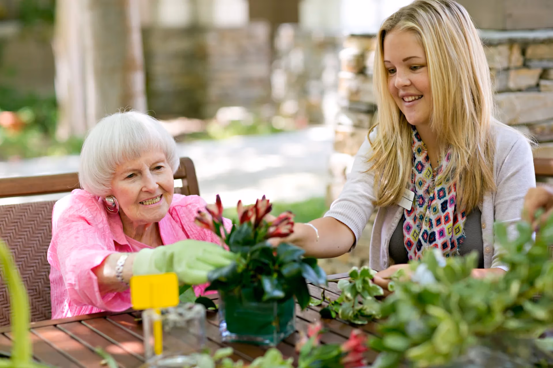 A resident and team member working on a flower-arranging activity together