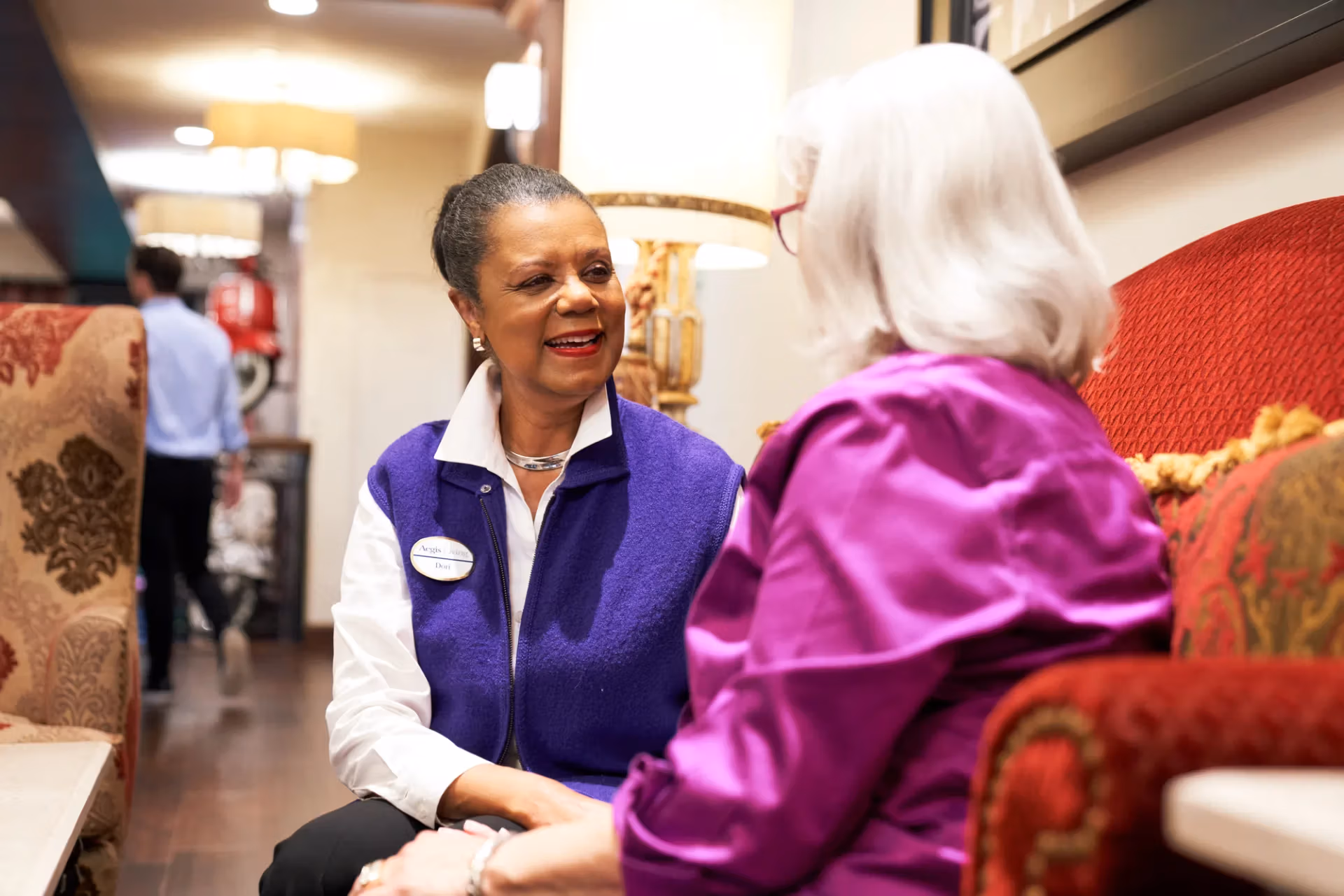 A team member checking in with a resident in the community lounge
