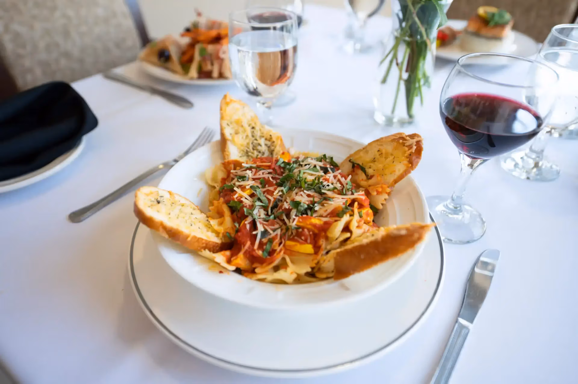 Pasta dish with garlic bread and wine