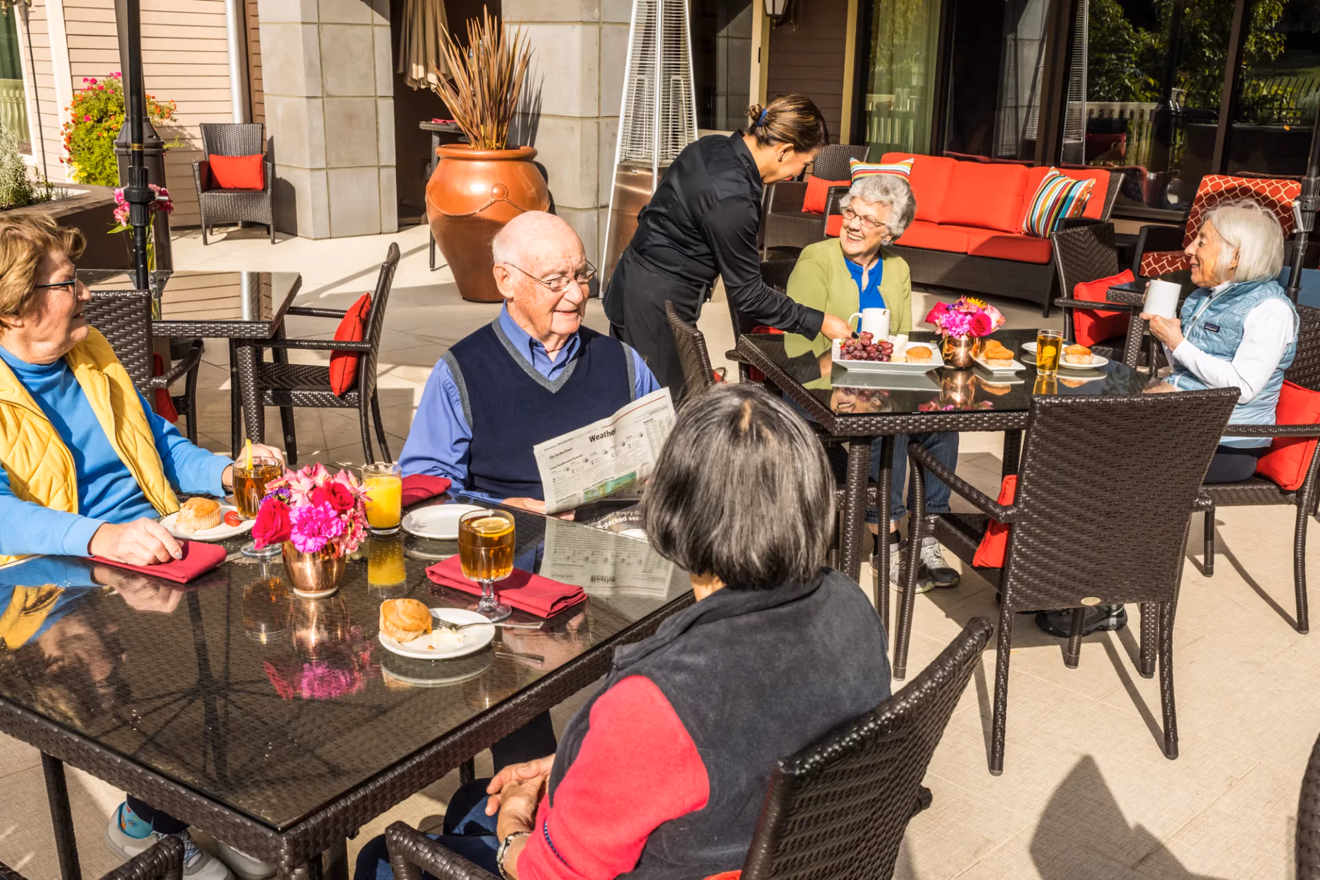 A server bringing meals to residents on the garden patio