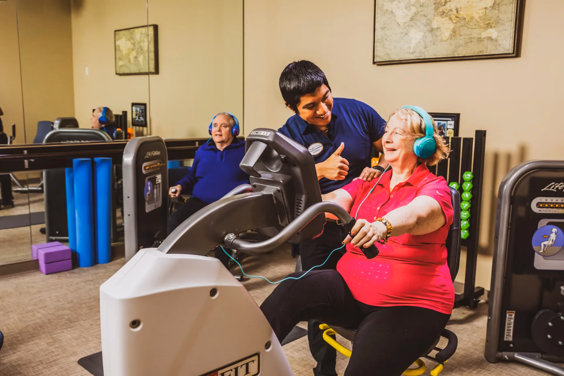 A trainer guiding a resident through a workout in the fitness studio