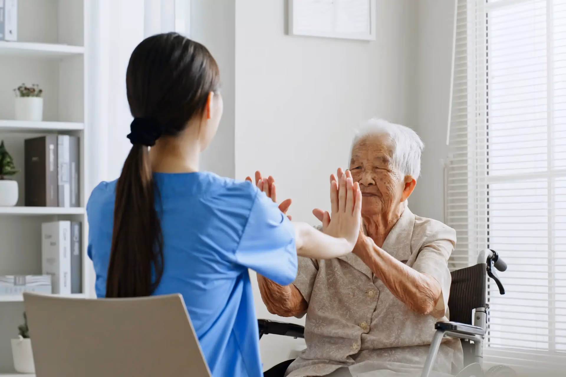 A therapist guiding an Áegis Living resident through in-apartment rehabilitation exercises