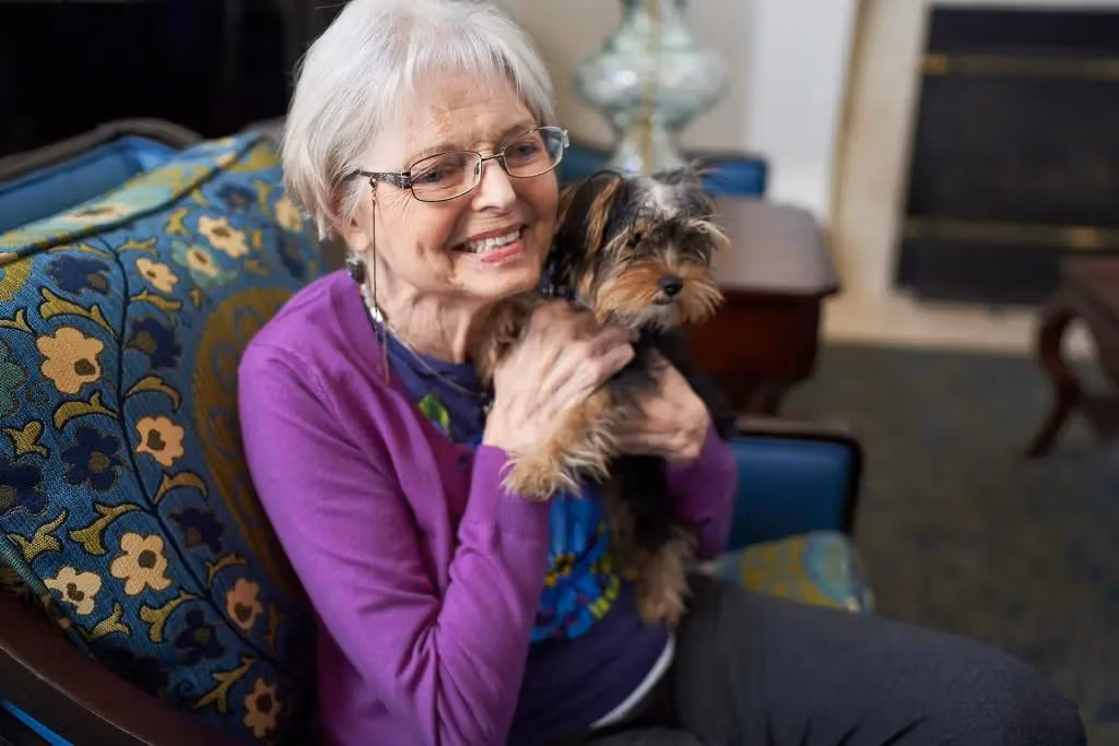 A resident greeting a visiting therapy dog