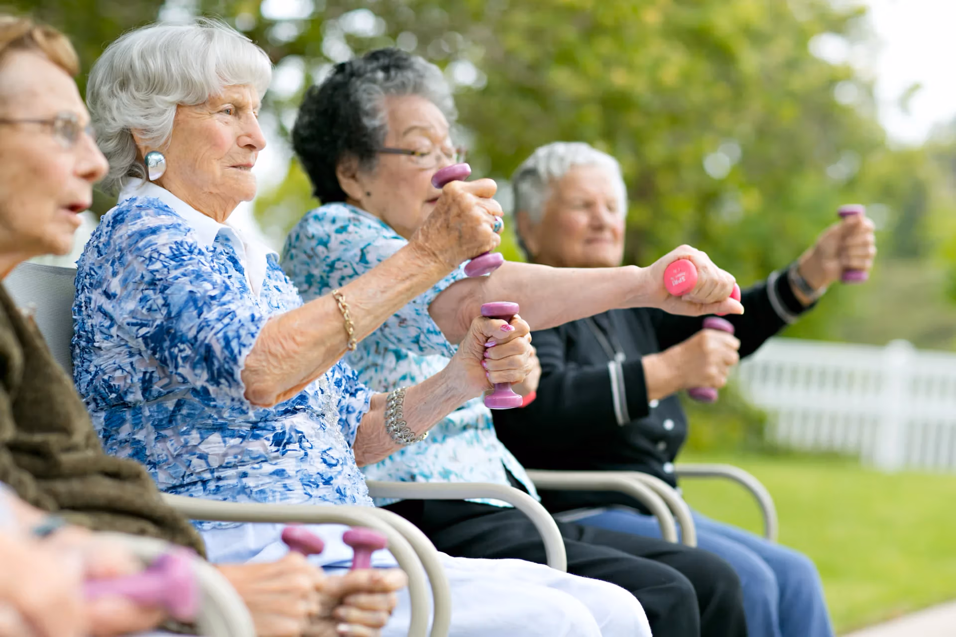 Residents lifting hand weights in an outdoor fitness class