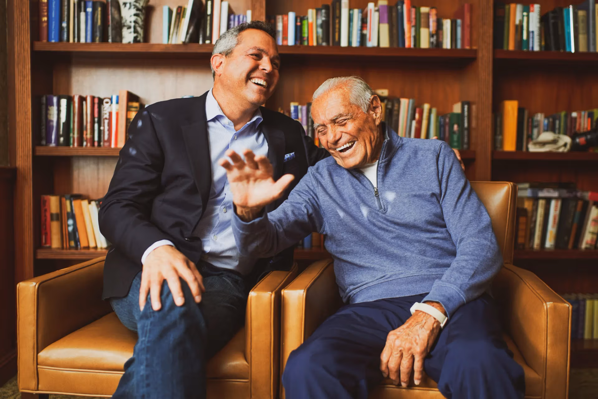A family member and resident laughing together in the community library