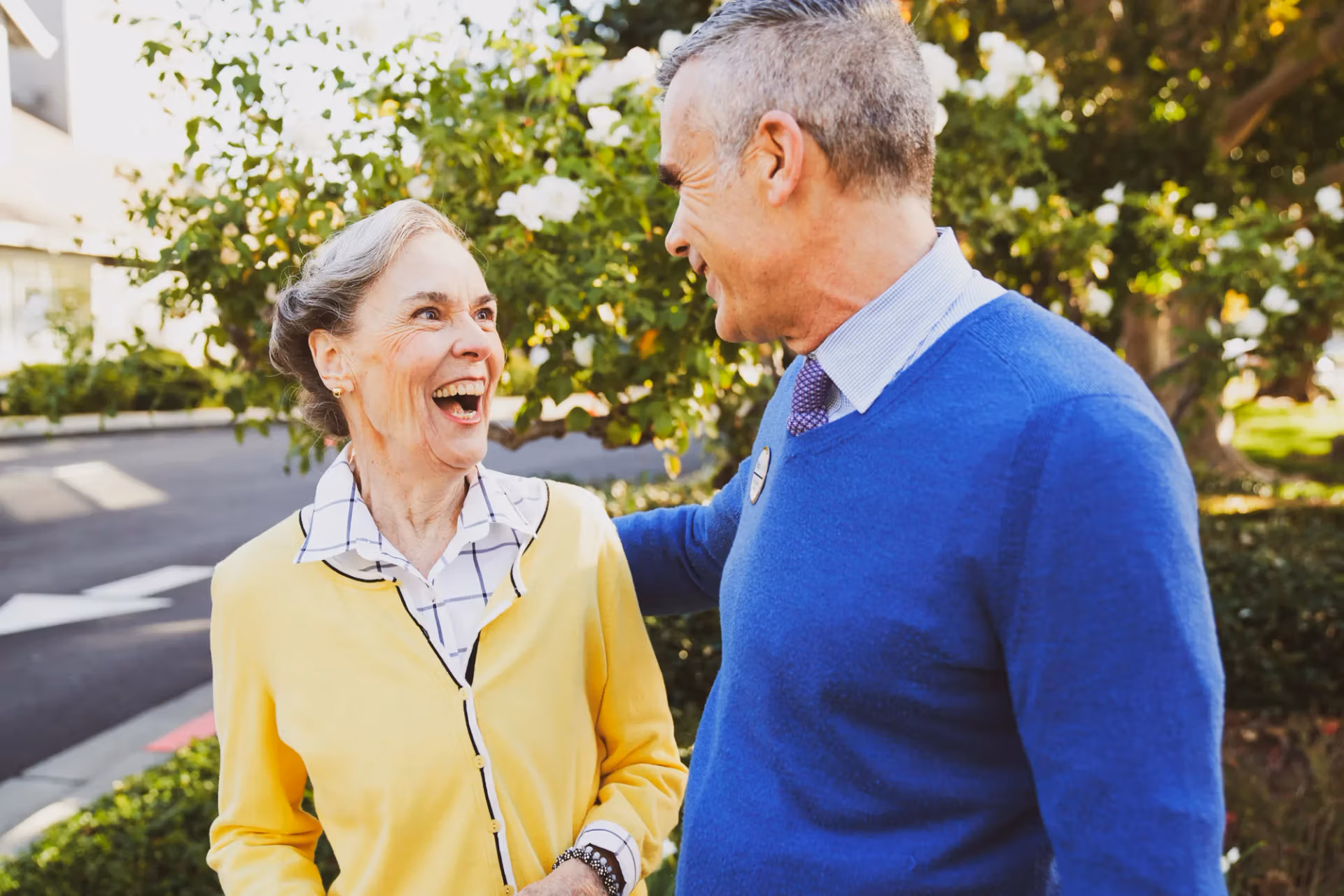 A team member warmly greeting a visitor outside the community