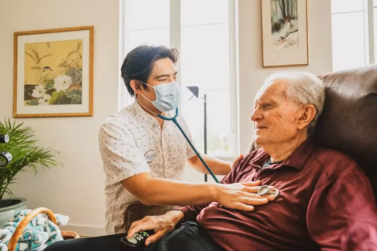照护人员的手轻轻覆在长者手上，传递安心