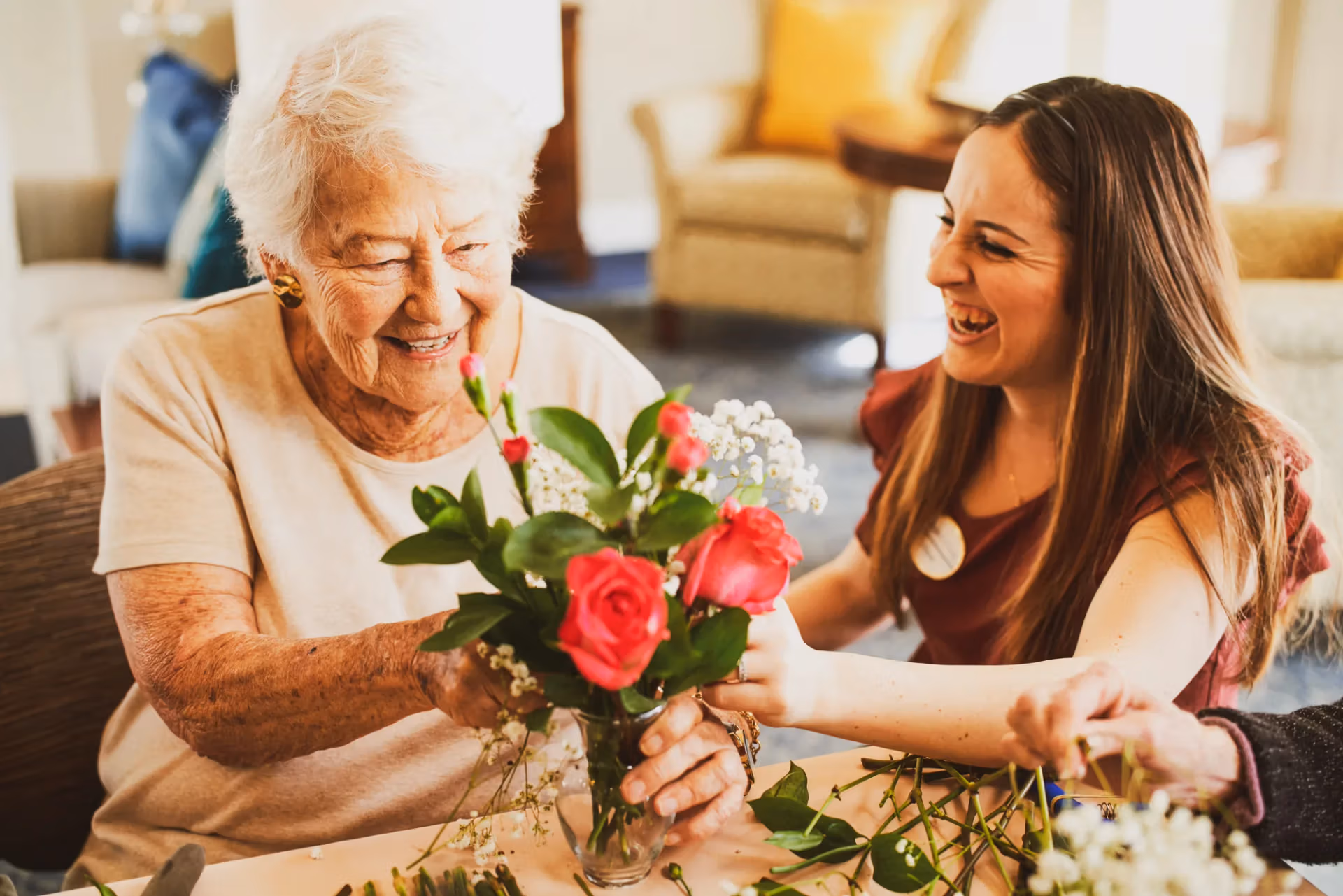A team member and resident arranging flowers together