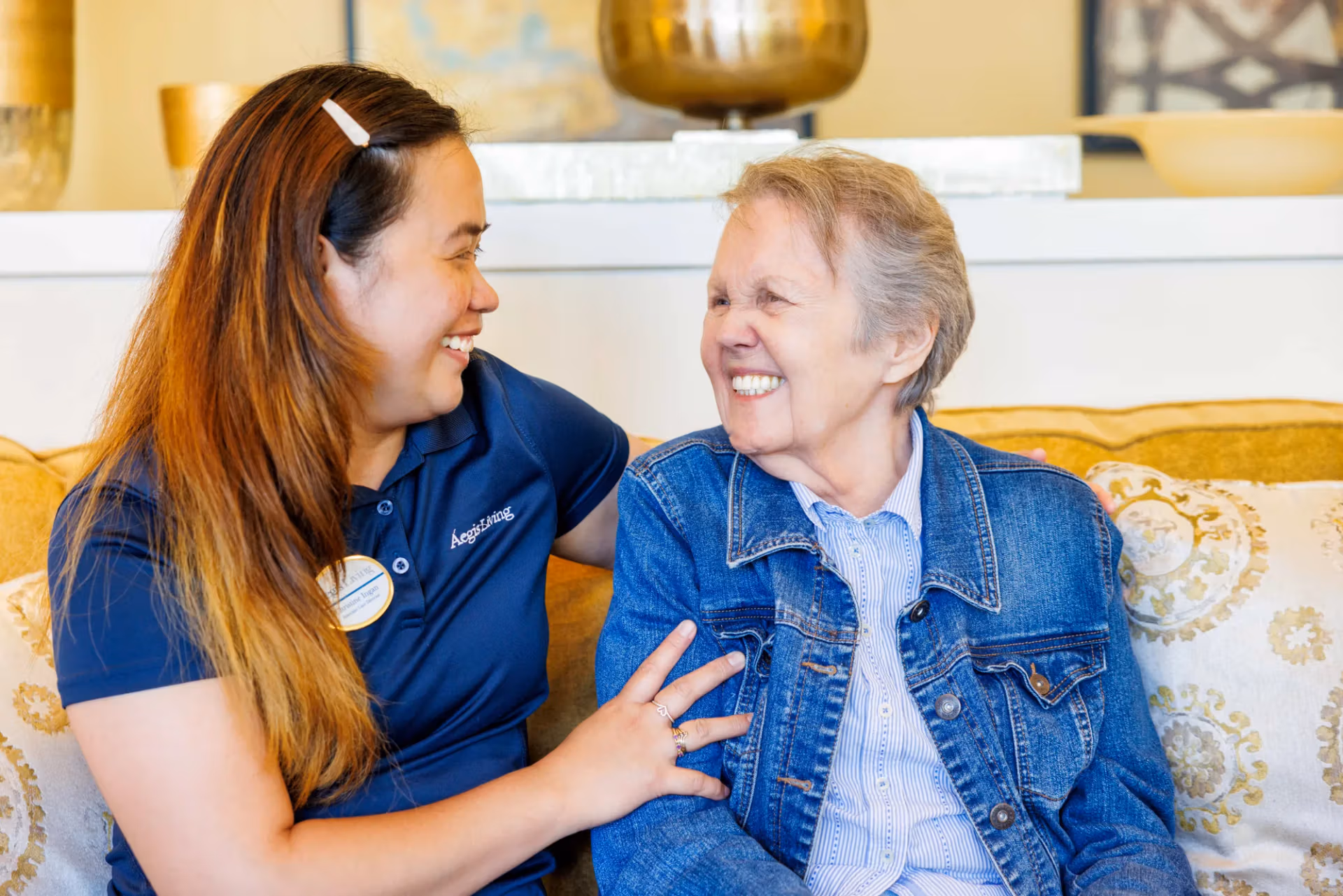 A team member sitting close beside a resident in gentle conversation